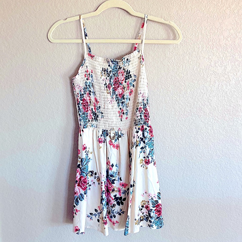 A cream colored sun dress with floral print